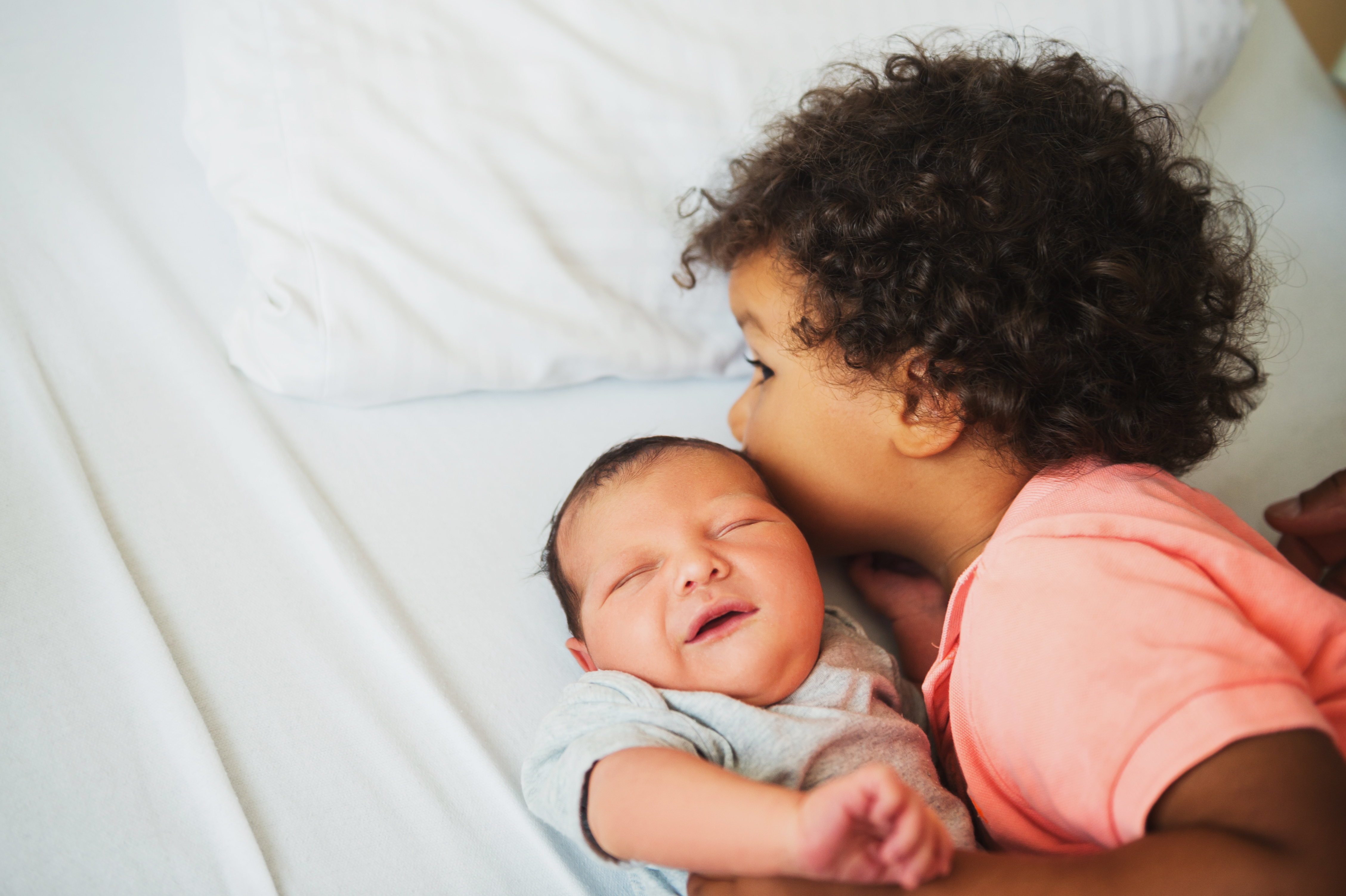 Kind k&uuml;sst Baby auf die Stirn